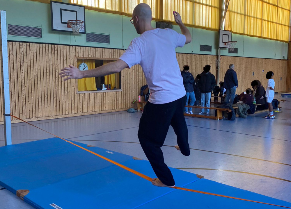 Lehrer balanciert auf Slakline